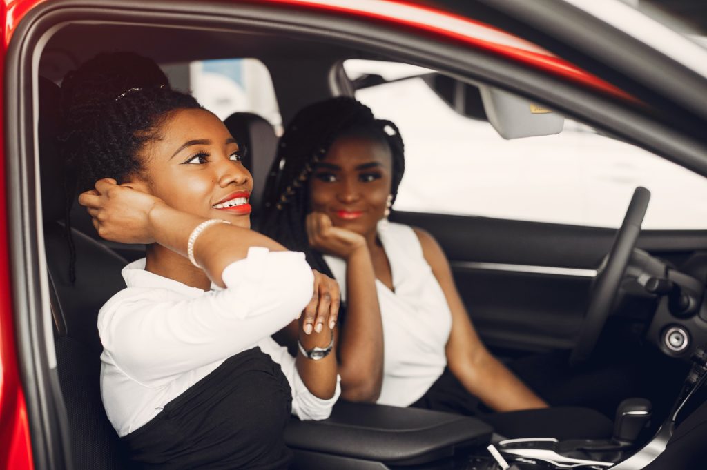 Two stylish black women in a car salon